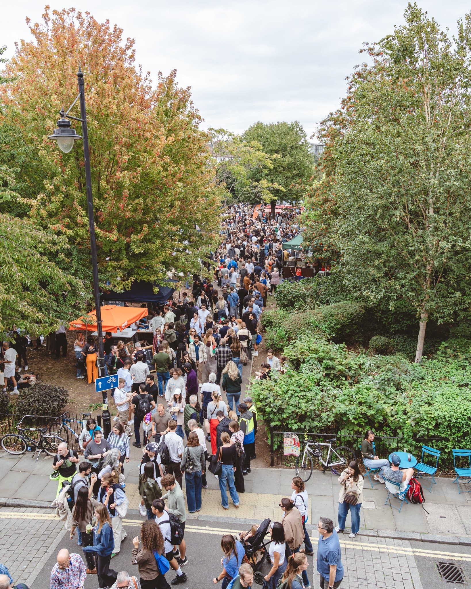 Bermondsey Street Festival, the road packed with people seen through the trees.