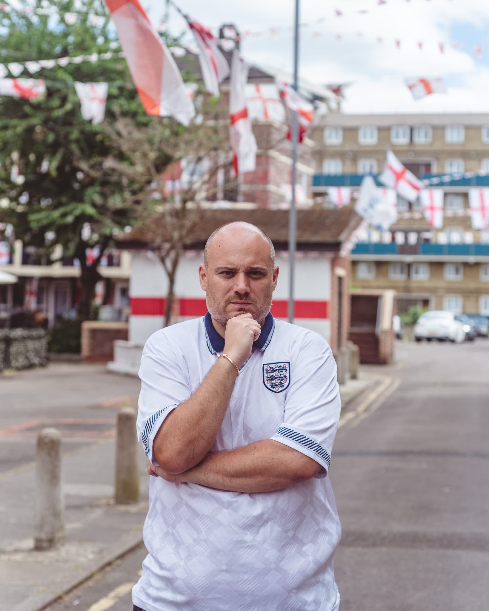 A man in an England shirt at a Bermondsey street party, bunting overhead.