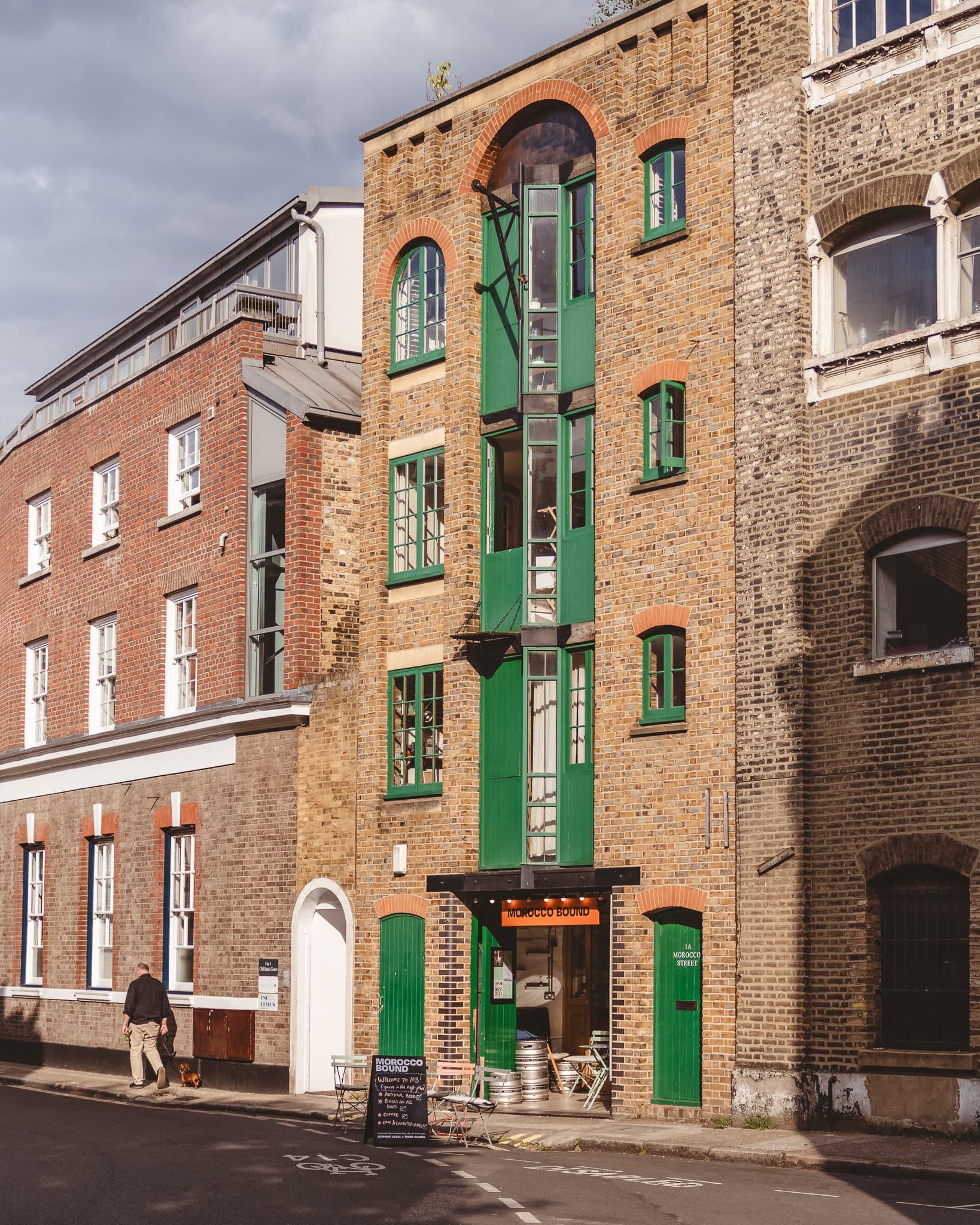A brick Bermondsey warehouse with green-painted shutters and doors.