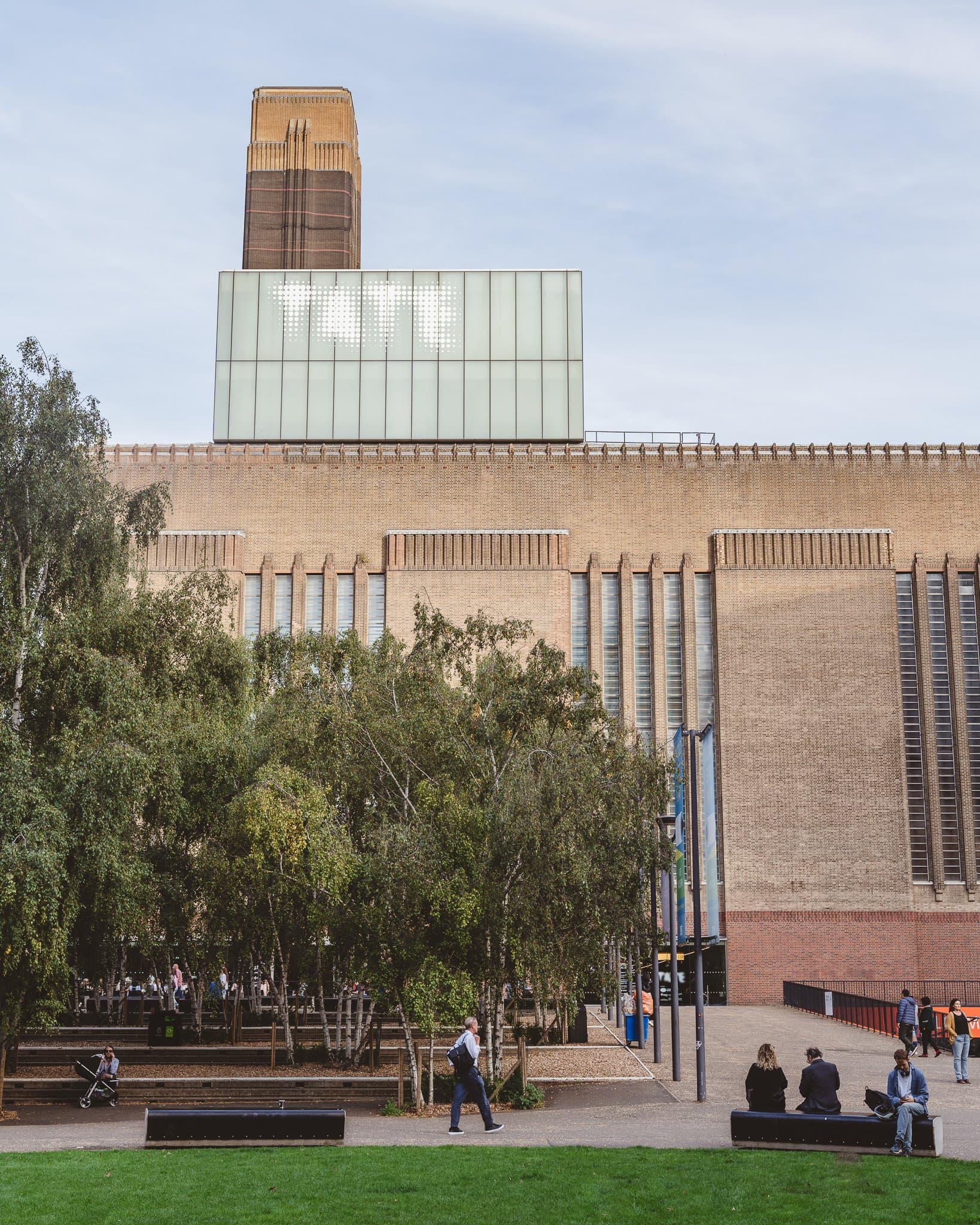 A gallery building set back behind its lawn and young trees.