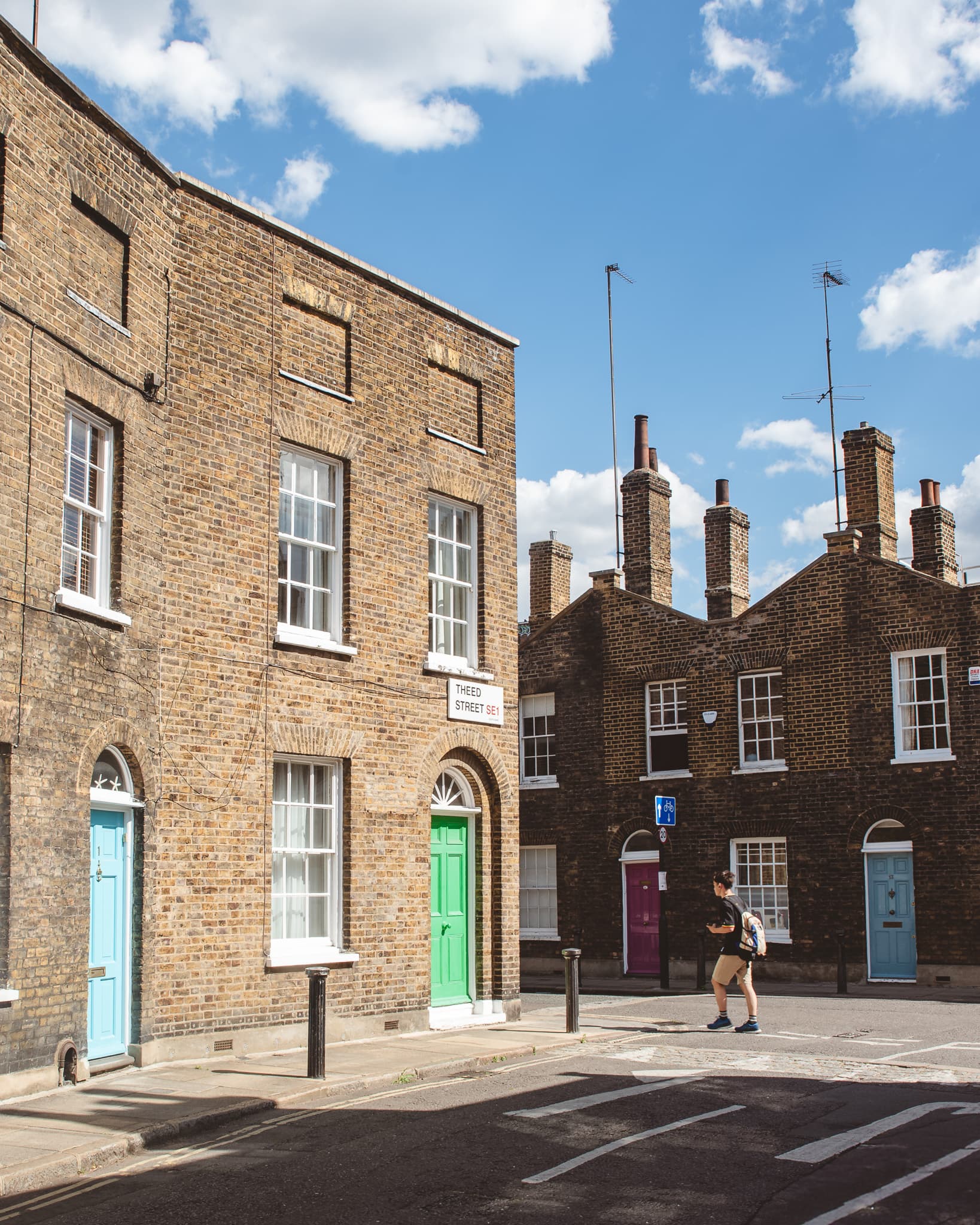 A row of brick Bermondsey terraces under a clear blue sky.
