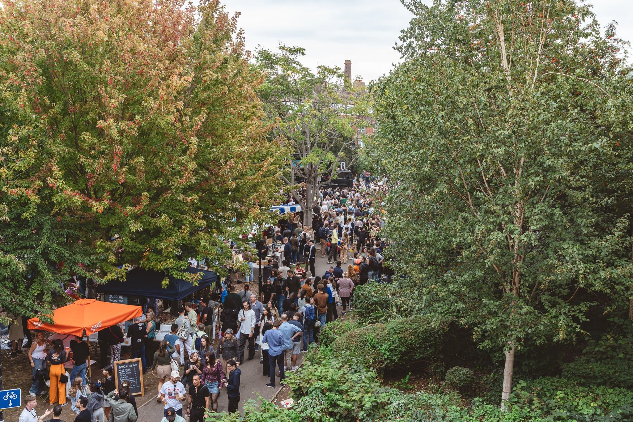 The crowded festival street seen from above through the trees.