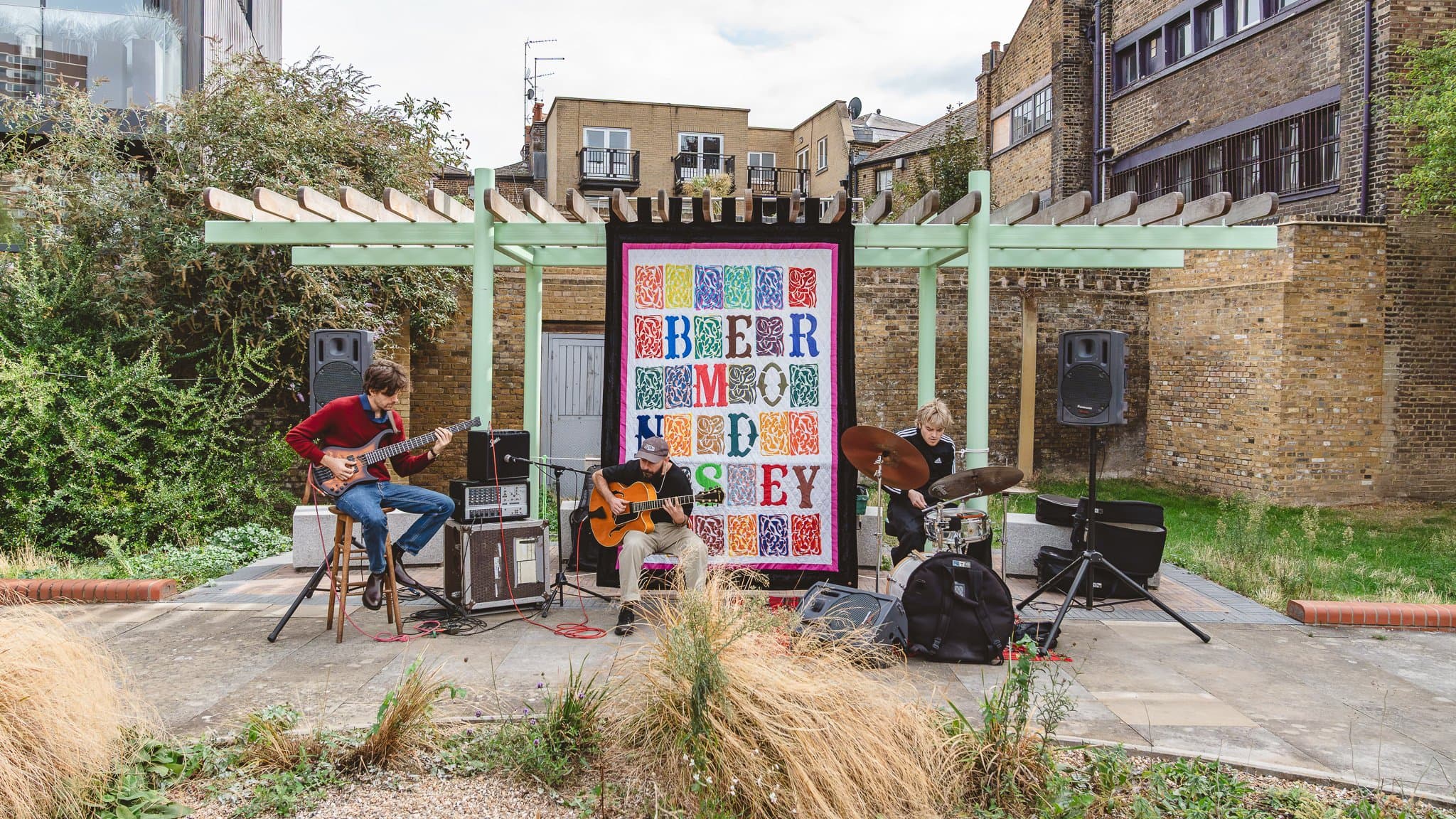Musicians playing on a small stage beside a Bermondsey sign.