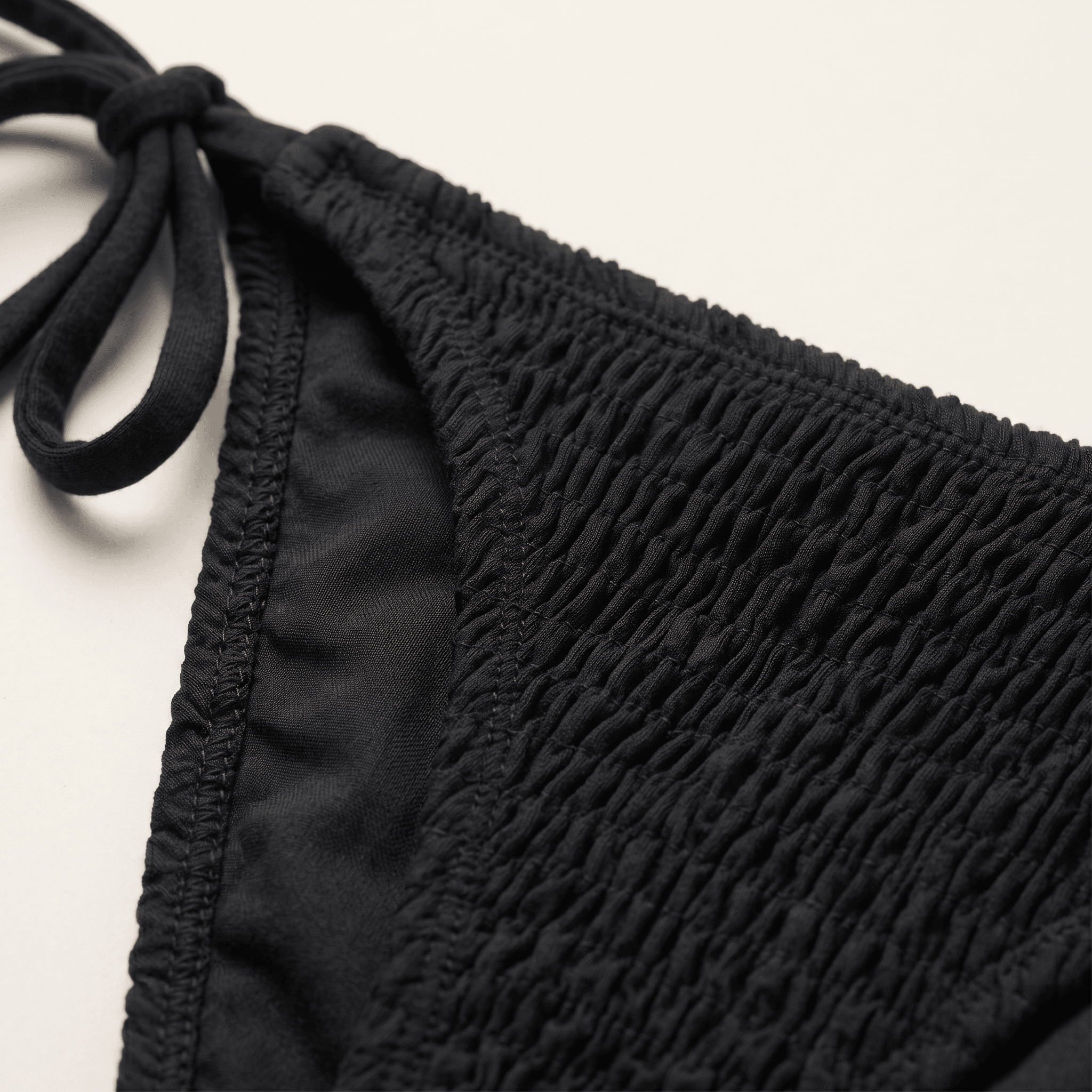 Macro crop of woven organic cotton, the individual warp and weft threads visible in the weave